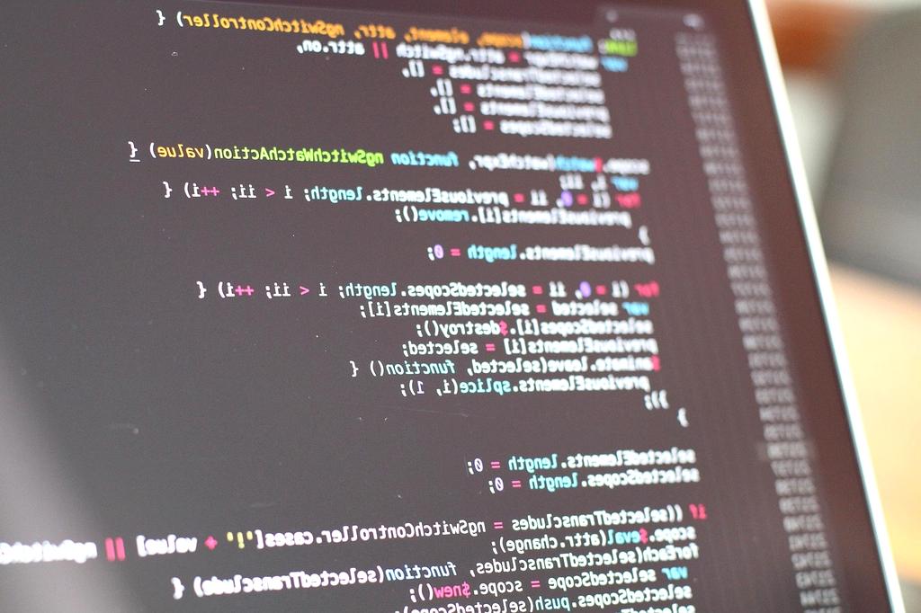 Team working on custom software code on multiple screens